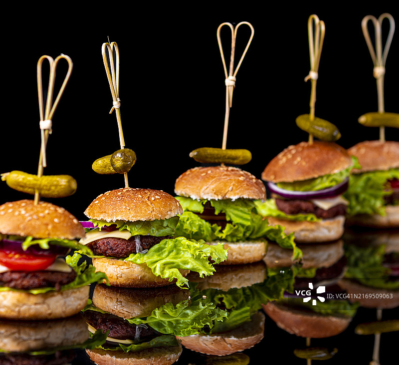 小素汉堡排成一排，深色背景，倒影图片素材