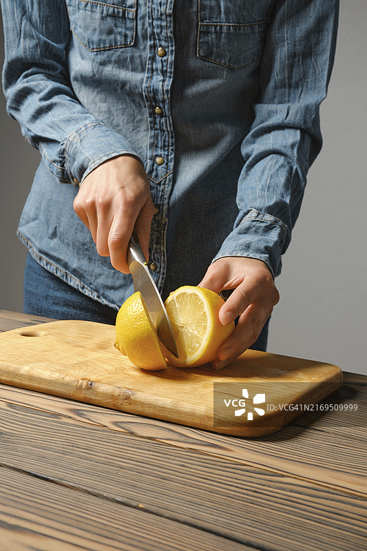 女性双手切割柠檬制作酱汁的特写图片素材