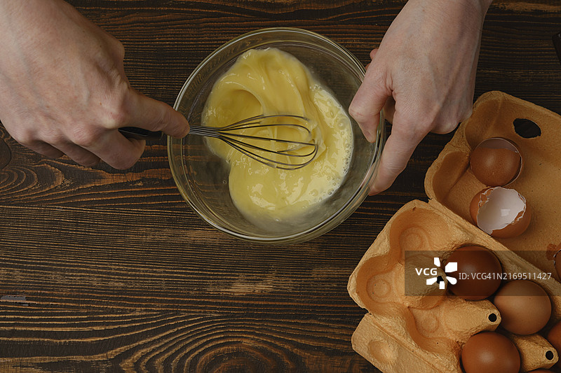 男子在玻璃碗中搅拌鸡蛋，顶视图图片素材