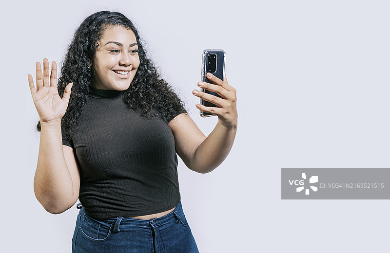 微笑的拉丁裔女子正在进行视频通话图片素材