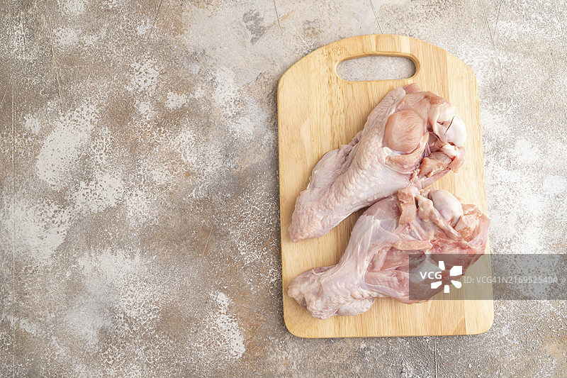 带香草和香料的生火鸡翅，在棕色水泥背景的木制砧板上。顶部视角，平铺，复制空间图片素材