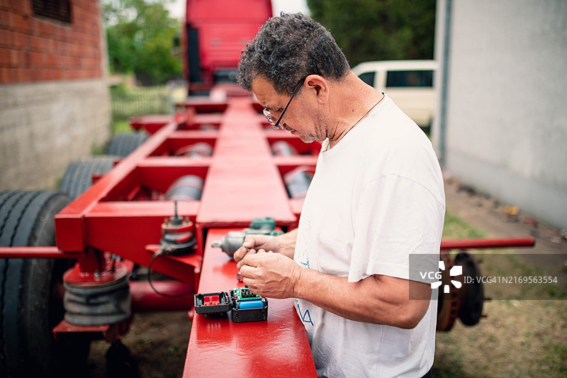男人正在修理电钻控制面板图片素材