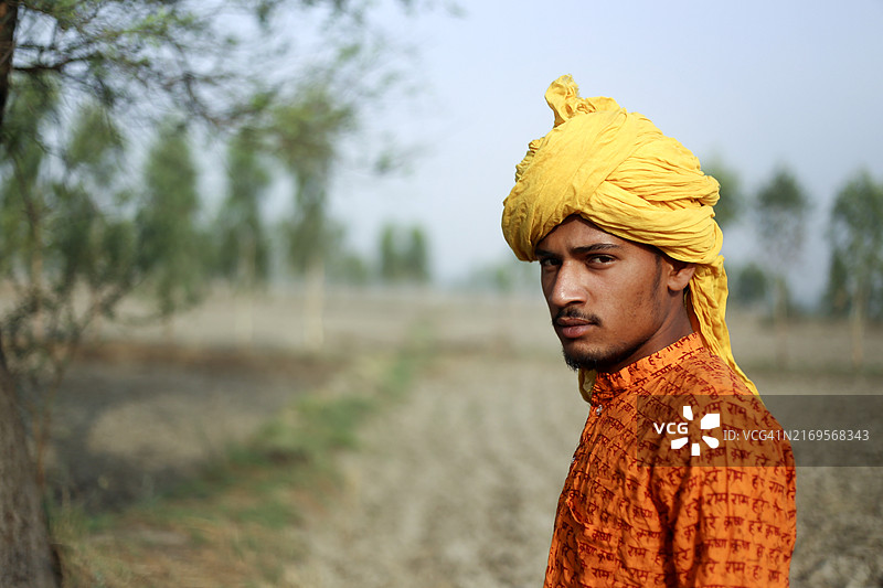 年轻农民在农田中站立的肖像图片素材