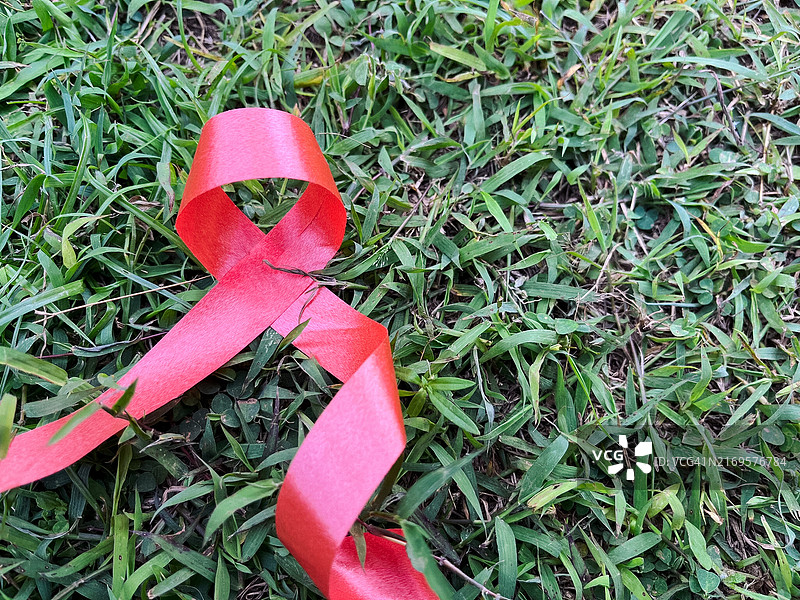 世界艾滋病日绿色草地上的红色丝带图片素材