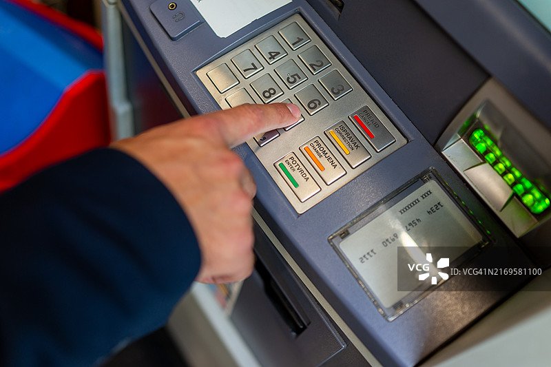 男人将密码输入ATM机图片素材
