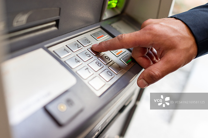 男人将密码输入ATM机图片素材