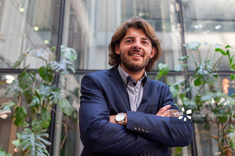 在办公室前为相机摆姿势的快乐商人图片素材