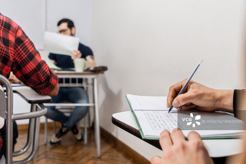 课堂上学生做笔记的特写图片素材