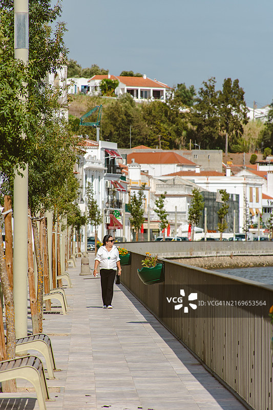 在阿尔卡塞尔杜萨尔的萨多河边行走的女人图片素材