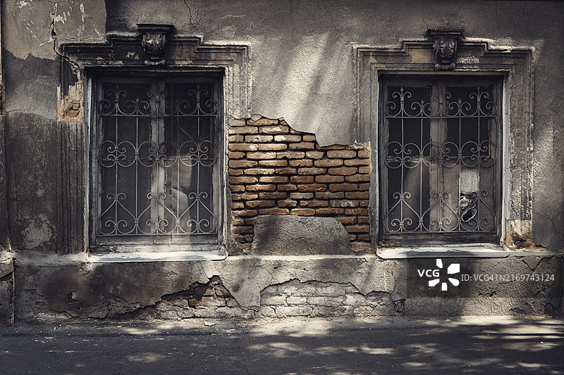 格鲁吉亚第比利斯一栋古老的风化住宅楼的两扇窗户图片素材