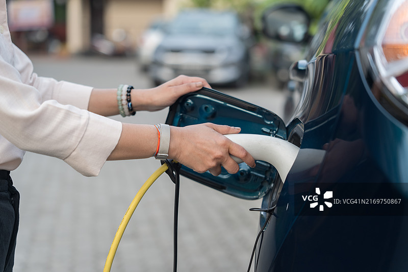 手持电动汽车充电器的特写镜头图片素材