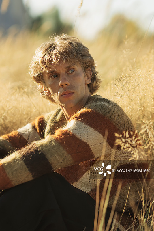 穿毛衣的金发男人，秋季景色图片素材