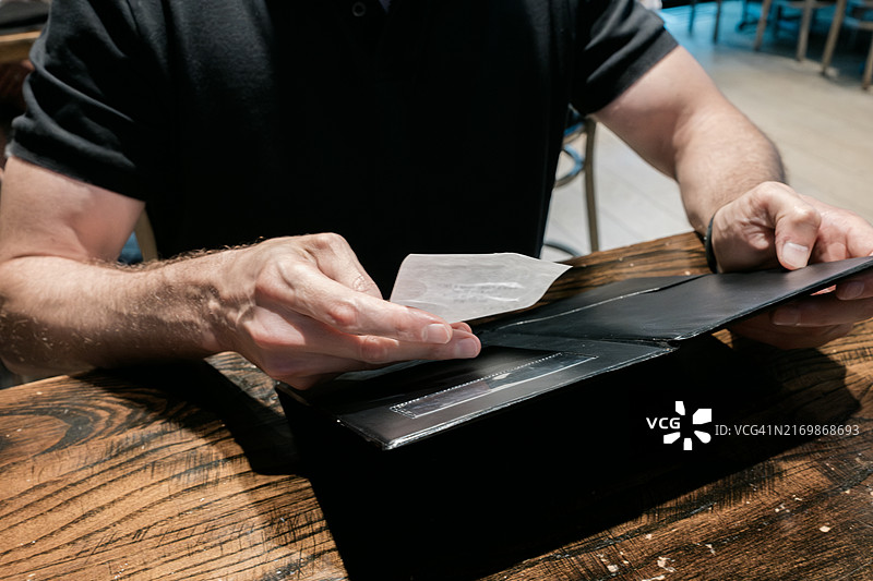 男子在餐厅查看账单图片素材