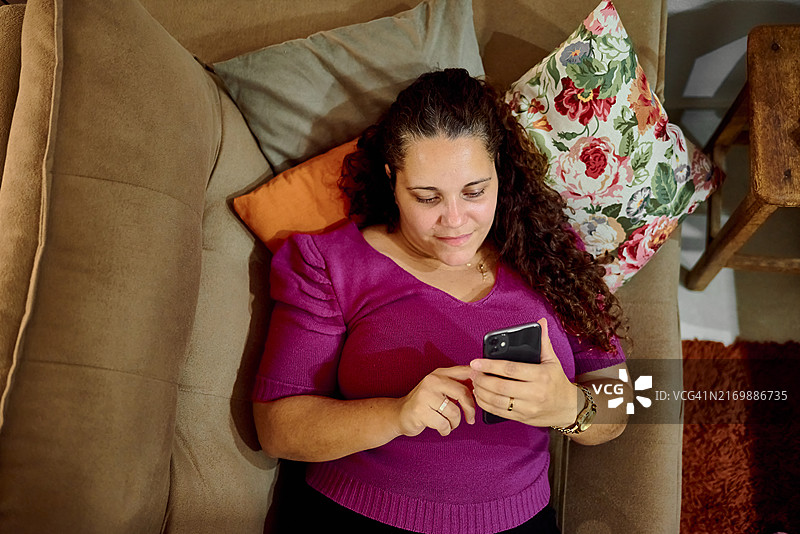 拉丁裔女性在手机上听播客图片素材