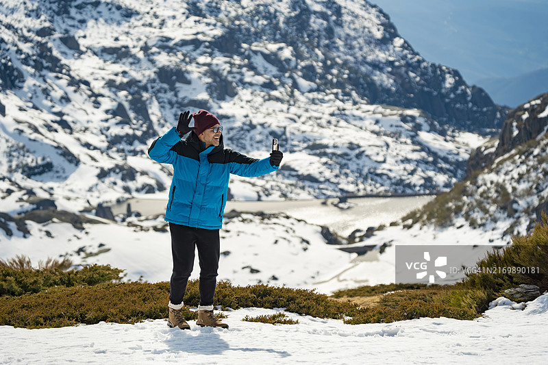 男子在雪地里进行视频通话图片素材