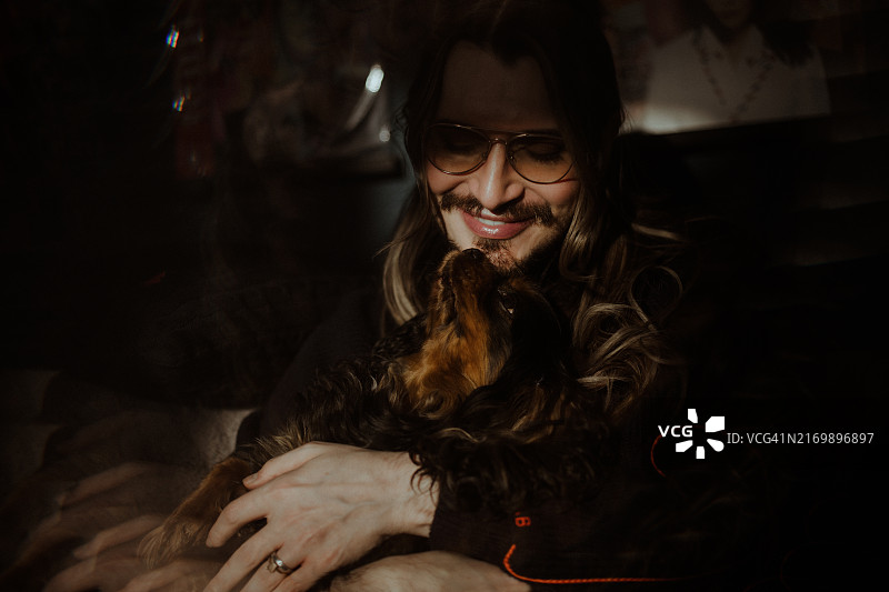 男人抱着查理士王小猎犬图片素材