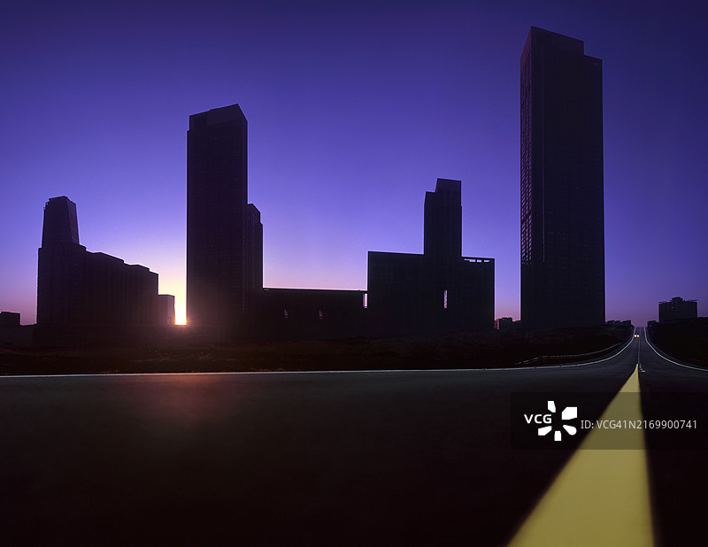 大型现代化城市天际线与日出时行驶的车辆图片素材