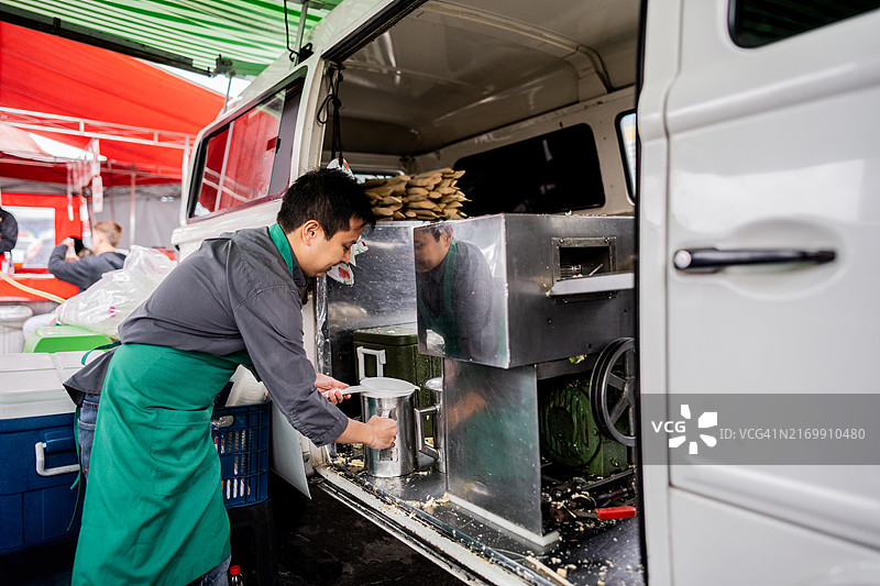 小贩在街头小摊准备甘蔗汁图片素材