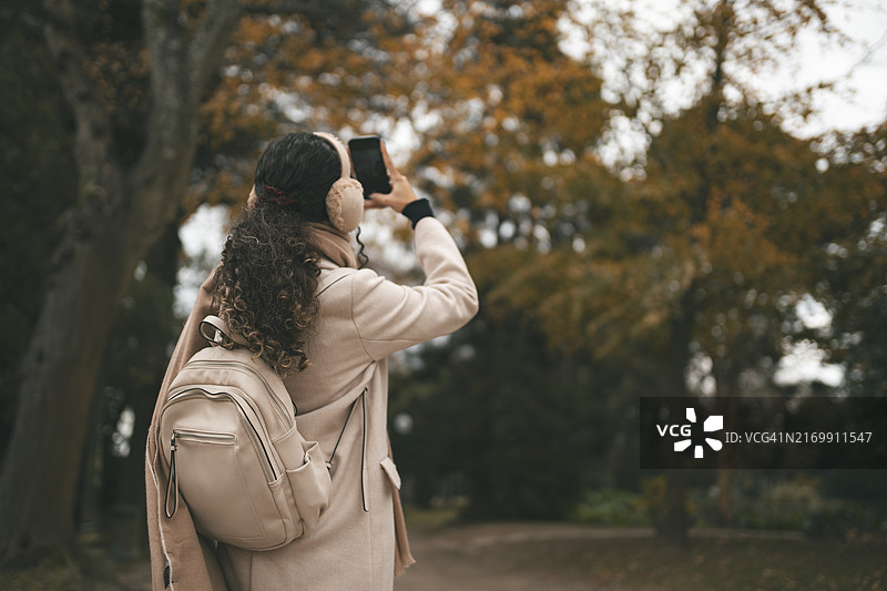在秋天拍摄自然风光的少女图片素材