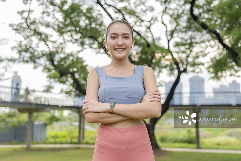 在花园里跑步锻炼后，面带幸福自信微笑的亚洲运动女性肖像图片素材