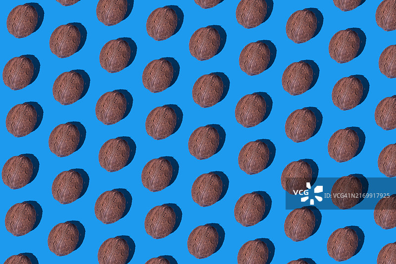 蓝色背景上的完整未开封椰子图案：夏季、健康生活方式、食物、水果、健康、热、饮品图片素材
