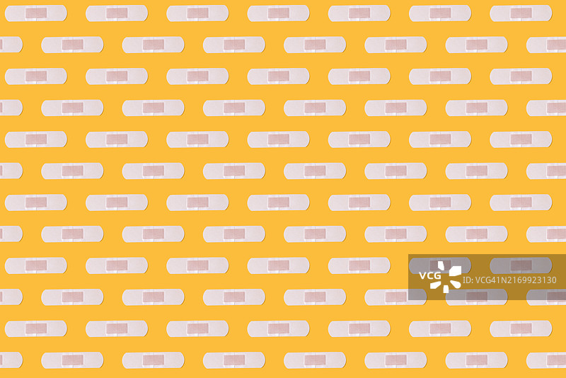 黄色背景上的创可贴图案：急救，身体护理，伤口，固定，解决，医药，恢复，补丁，医院图片素材