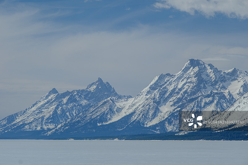 覆盖冰面的杰克逊湖上的雪山图片素材