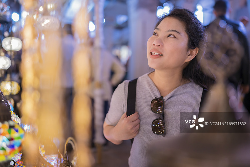 有魅力的亚洲年轻女性游客在土耳其伊斯坦布尔大巴扎购物，在当地市场享受快乐无忧的休闲购物图片素材