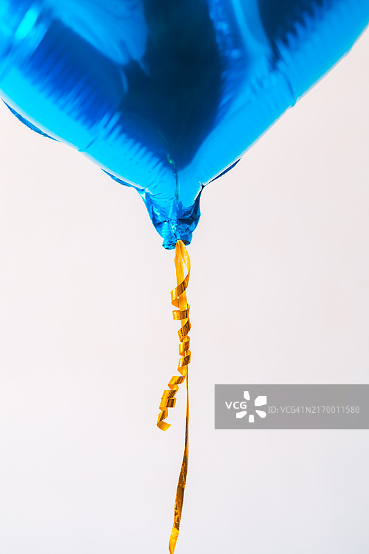 白色背景上的金属蓝色氦气球特写图片素材