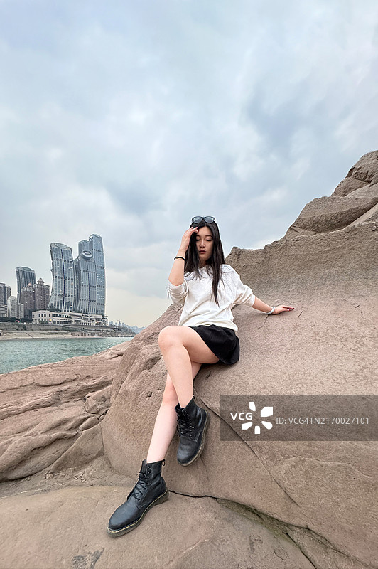 现代城市中拥有城市天际线和摩天大楼的年轻女性图片素材