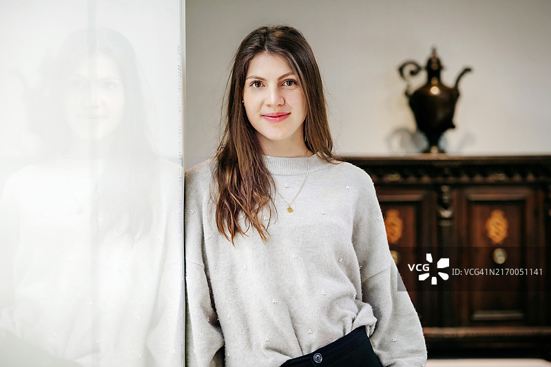 在博物馆摆姿势的自信的年轻女人的肖像图片素材