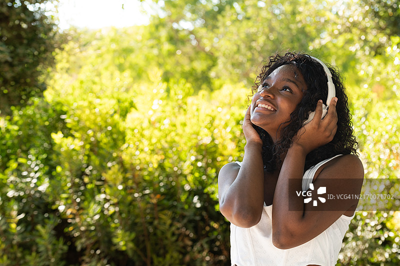 年轻女子在户外戴耳机享受音乐图片素材