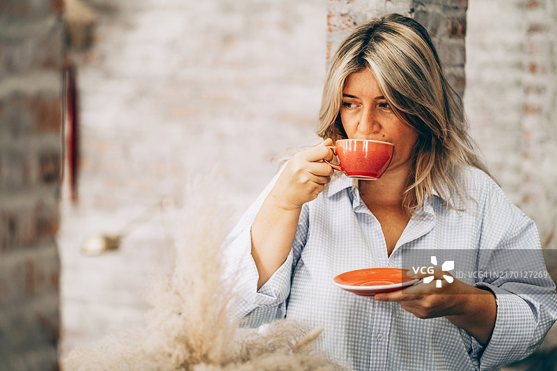 享受早晨咖啡的沉思年轻女性图片素材