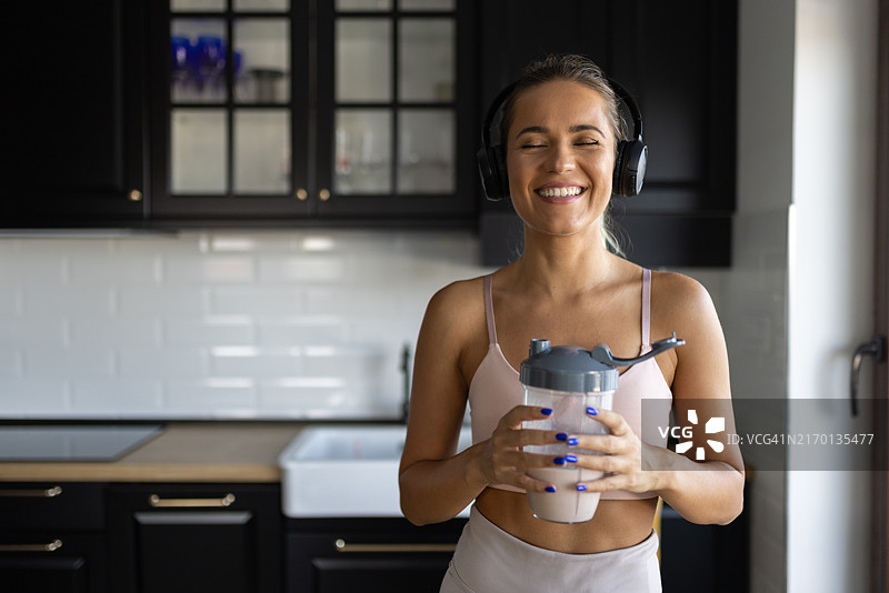 女运动员在厨房喝冰沙图片素材