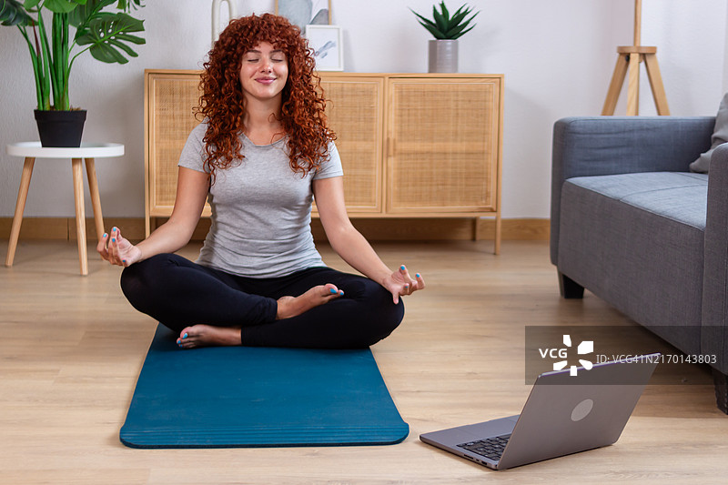 年轻女人在家进行在线瑜伽冥想图片素材