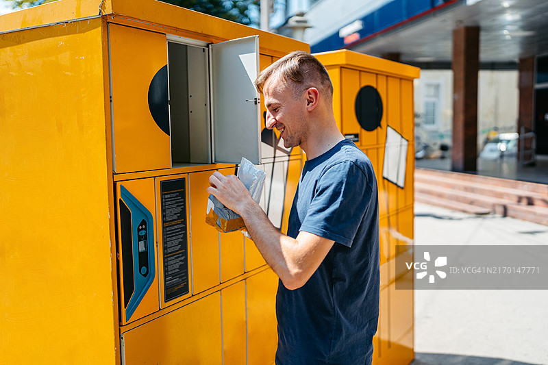 男人从自助邮局终端机取邮件图片素材