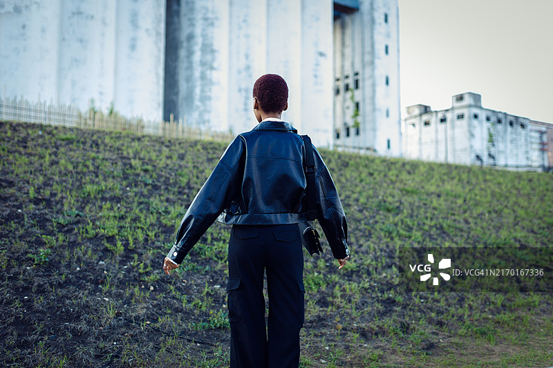 非洲裔苗条女人在草坡与建筑前图片素材