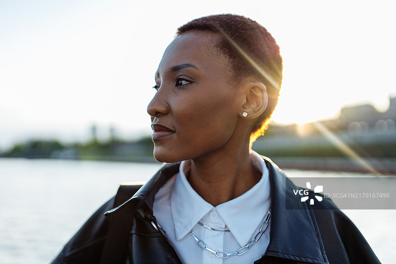 日落时分，站在湖边的多种族肤色短发女子肖像图片素材