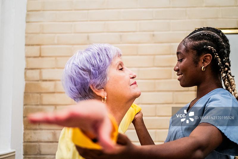 理疗师帮助老年妇女在家锻炼图片素材