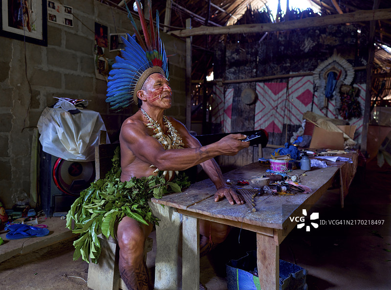 巴西亚马逊部落原住民用遥控器在智能电视上换台图片素材