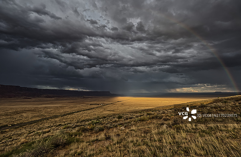 美国亚利桑那州朱红悬崖国家纪念碑上空的灰色暴风云和彩虹图片素材