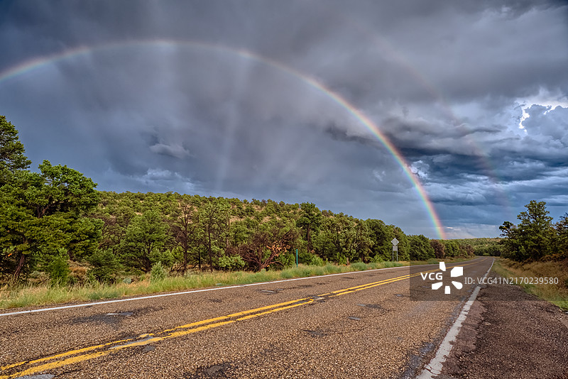 笔直道路上的彩虹和暴风云，凯巴布国家森林，美国亚利桑那州图片素材