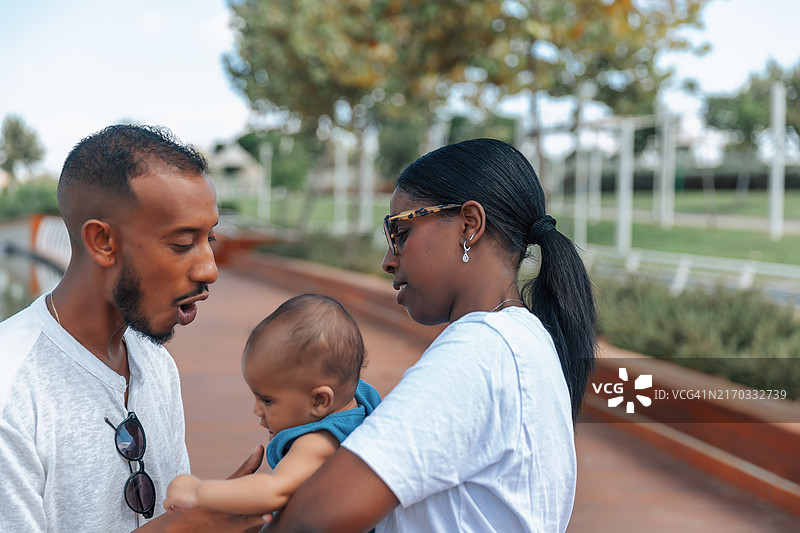 父亲与宝宝互动，母亲抱着图片素材