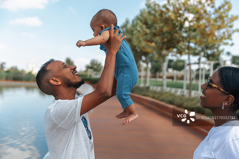 父亲在湖边举起婴儿图片素材