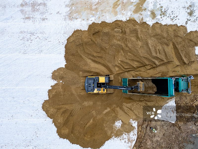 挖掘机将沙子装入倾卸卡车图片素材