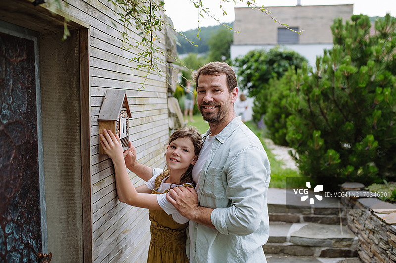 女孩在家安装昆虫旅馆，父亲帮忙安装图片素材