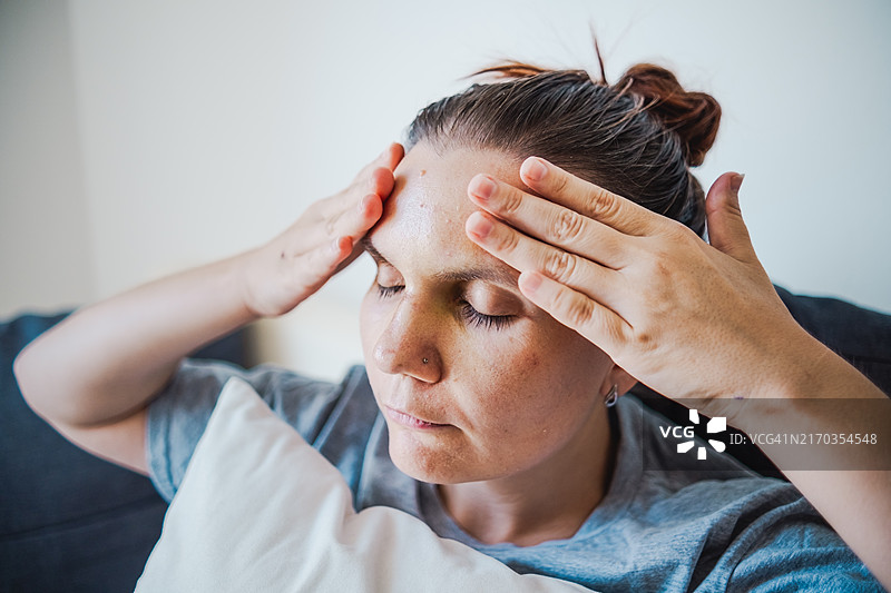 受伤的女人触摸她的脸图片素材