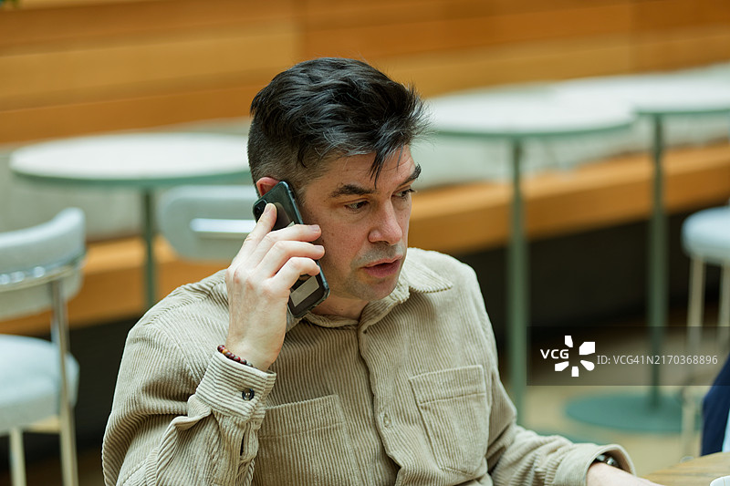 在巴黎公司休息室打电话的商务人士肖像图片素材