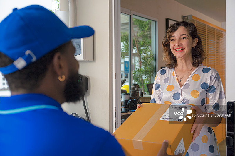 女顾客从快递员手中接收包裹图片素材