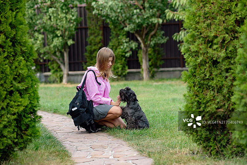 返校季：背着书包快乐上学的女学生图片素材
